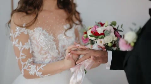 The bride puts the wedding ring on finger of the groom Stock Footage 132697135