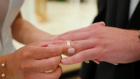 The bride puts the wedding ring on the finger of groom, at the wedding ceremony Stock-Footage 314589394