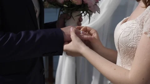 The bride puts on a wedding ring to the groom at a wedding ceremony. Stock Footage 115933518