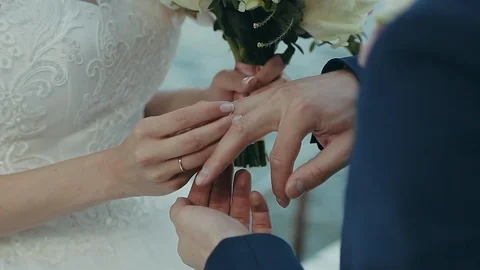The bride puts the wedding ring on the groom's finger. Wedding ceremony near the Vídeos de archivo 108486836