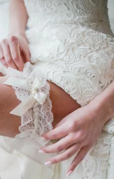The bride putting on garter Stock Photos