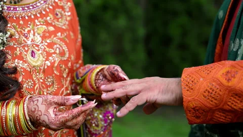 Bride is putting on the wedding ring on groom hand. Elements of Hindu bright Stock Footage 318049211