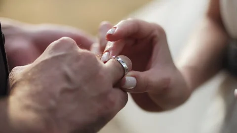 Bride Putting Wedding Ring on Grooms Finger Stock Footage 312145390