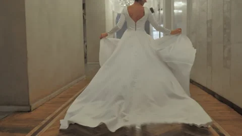 The bride runs down the hall holding her dress. Stock Footage 151775204