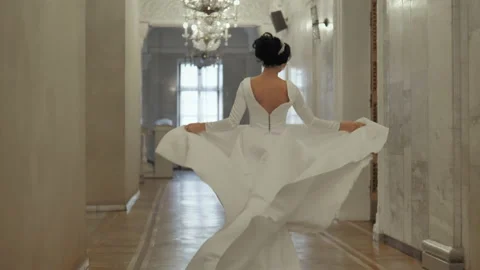 The bride runs down the hall holding her dress. Stock Footage 151775390