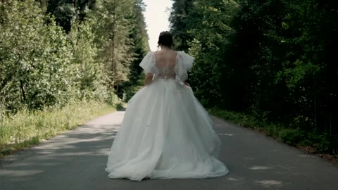  the bride runs with her back to the camera on a sunny clear day Stock Footage 263728405