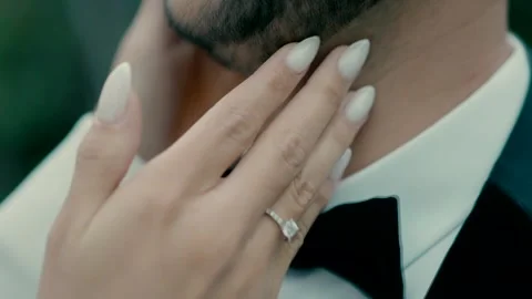 A bride runs her hand over the groom's face. wedding day. Video stock 221703593