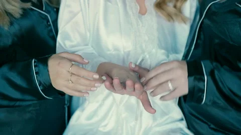 A bride shows the ring with a diamond on her finger to two of her friends. Stock Footage 230012510