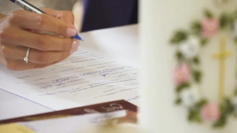 Bride sign wedding papers at christian wedding, candle in background. Stock Footage