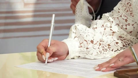 The bride signs the marriage documents. Close-up of a woman signing documents Stock Footage 238026126