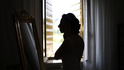 Bride silhouette settles in front of the mirror. Stock Footage 94428593