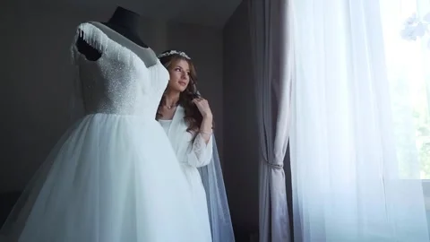 Bride In Silk Dressing Gown Holding And Admiring Her Beautiful Wedding Dress Stock Footage 242426967