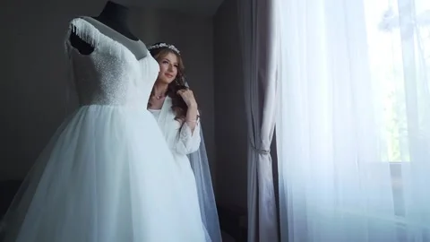 Bride In Silk Dressing Gown Holding And Admiring Her Beautiful Wedding Dress Stock Footage 244009763