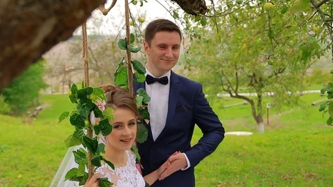 The bride sits on a beautiful swing Stock Footage 75023675