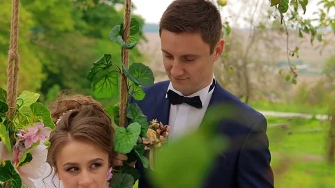 The bride sits on a beautiful swing Stock Footage 75023831