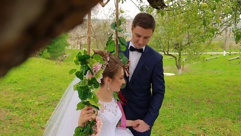 The bride sits on a beautiful swing Stock Footage 75024002