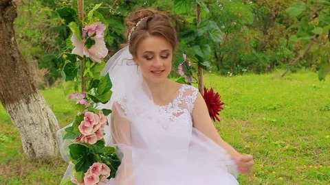 The bride sits on a beautiful swing Stock Footage 75024713
