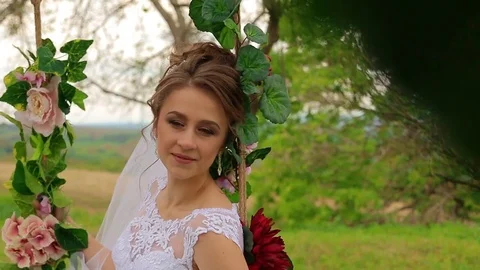 The bride sits on a beautiful swing Stock Footage 75025353