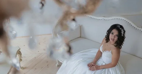 Bride sits on the couch / shooting the camera from the top Stock Footage 82332324