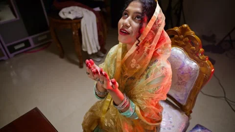 Bride sits lifting her hand in worship on wedding night Stock Footage 300363056