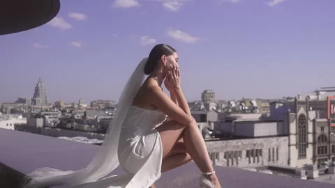 The bride sits on the parapet at the edge of a skyscraper Vidéo 262364794