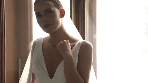 The bride sits by the window and poses for the camera Video stock 261734725