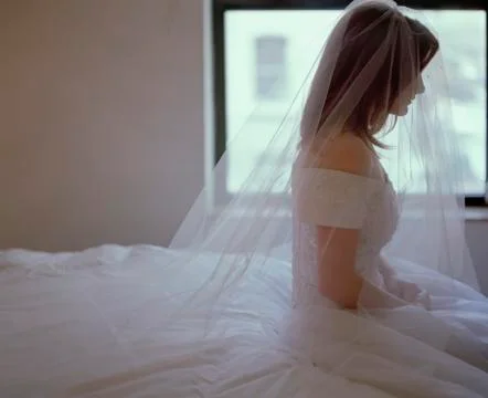 A bride sitting on a bed Stock Photos