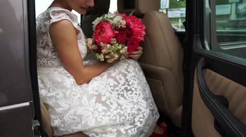 Bride sitting in the car with flowers Stock Footage 61783660