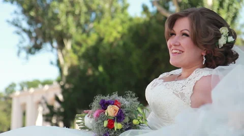 Bride sitting on the lawn with flowers Stock-Footage 58973799
