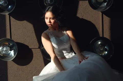 The bride is sitting on the sofa and looking out the window.sun ray.wedding g Stock Photos