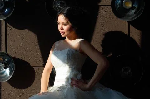The bride is sitting on the sofa and looking out the window.sun ray.wedding g Stock Photos