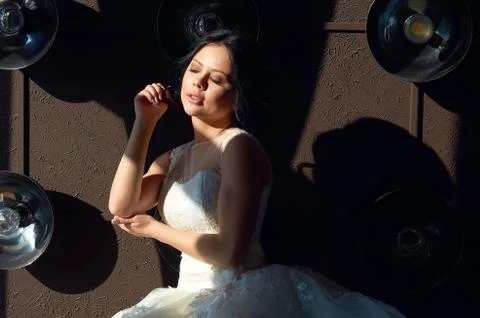 The bride is sitting on the sofa and looking out the window.sun ray.wedding g Stock Photos