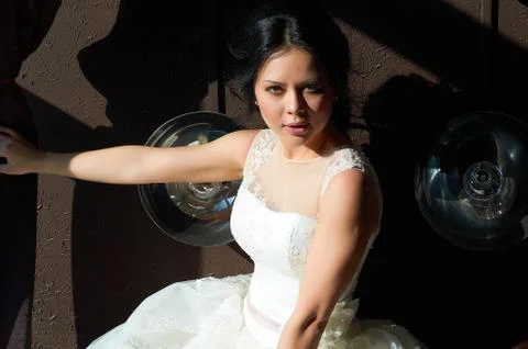 The bride is sitting on the sofa and looking out the window.sun ray.wedding g Stock Photos