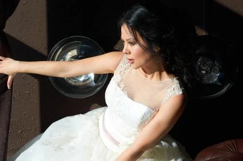 The bride is sitting on the sofa and looking out the window.sun ray.wedding g Stock Photos