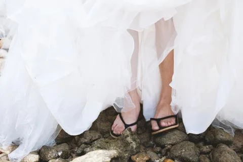 Bride with slipper on the pebble stone Фото