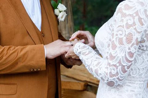 The bride slips the wedding ring onto the groom's finger during the wedding Fotos Stock