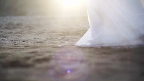 Bride slowly walking on sandy beach Stock-Footage 97894811
