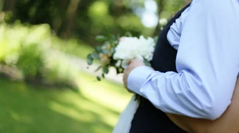 The bride standing behind groom and hugs him. Wedding session in the park Stock Footage 65502128