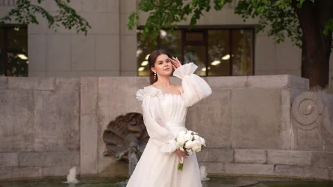 Bride standing by the fountain Stock Footage 246155012