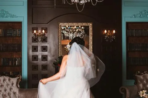 The bride is standing in front of a mirror in a beautiful room. Foto stock