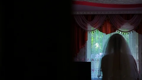 Bride standing near the window before the wedding Stock Footage 82948362
