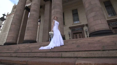 Bride standing on the steps near the columns Stock Footage 61872316