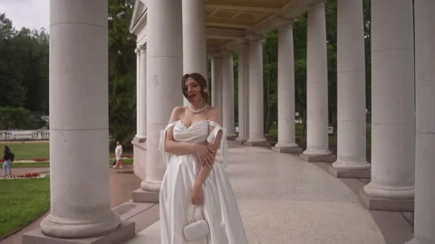 The bride stands among the columns and turns to the camera. Vidéo 263061952