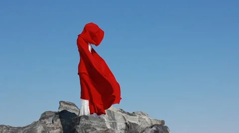 Bride stands on cliff with red flowing fabric Stock Footage 48785657