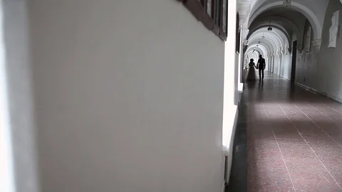 Bride stands before groom in white corridor inside Video stock 71365255