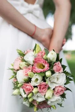 The bride stands with her back. In the hands of a small wedding bouquet of flowe 스톡 사진