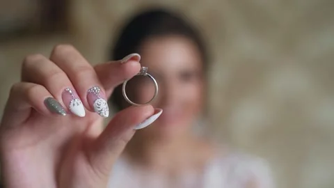 Bride stands in her room and looks through the wedding ring. Slow motion Stock Footage 211397231