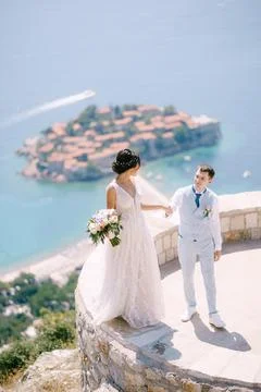 The bride stands on the parapet of the observation deck overlooking the island Foto stock