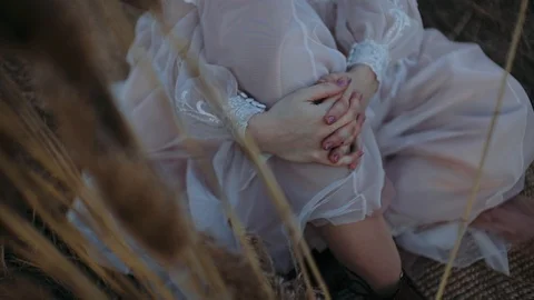 The bride strokes her leg while sitting on the ground Stock Footage 129928005