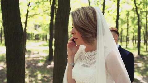 The bride talks by mobile phone in forest slow motion Stock Footage 54077450